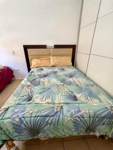 a bedroom with a bed with a blue and white comforter at Moderno dpto céntrico CNH in Santiago del Estero