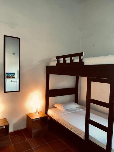 a bedroom with two bunk beds and a mirror at HOTEL CASA BRESSE in Cali