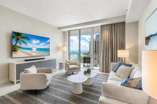 a living room with a couch and a tv at Luxury Ocean View 2BR in Riviera Beach
