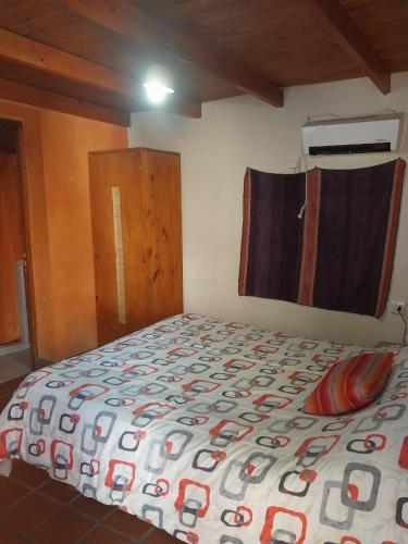 a bedroom with a bed with a comforter on it at Casa M in Tilcara