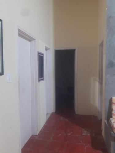 a hallway with white walls and a black door at Casa Marina Morro Branco in Beberibe