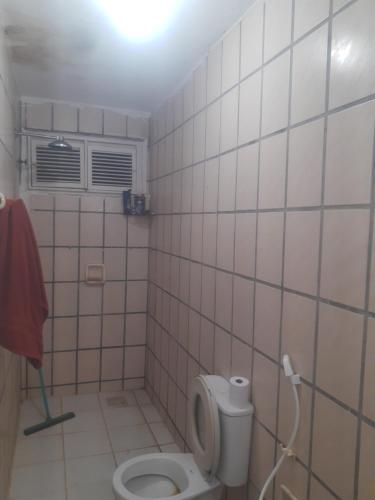 a bathroom with a toilet in a tiled room at Casa Marina Morro Branco in Beberibe