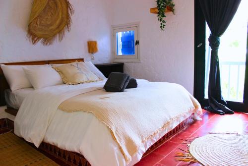 a bedroom with a large bed with white sheets at Espectacular dúplex a pie de mar in Cabo Negro