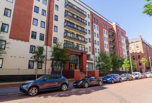 a row of cars parked in front of buildings at Central City Apartment - Free Parking in Belfast