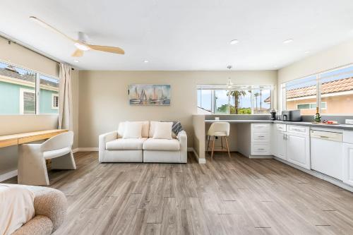 a living room with a white couch and a kitchen at Del Mar Studio - Walk to Beach in San Diego