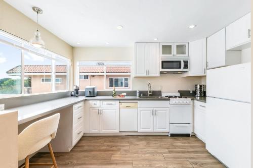 a kitchen with white cabinets and a large window at Del Mar Studio - Walk to Beach in San Diego