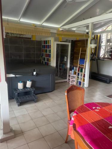 a room with a bed and a table and chairs at Villa Ti Balcon avec jacuzzi in Fort-de-France