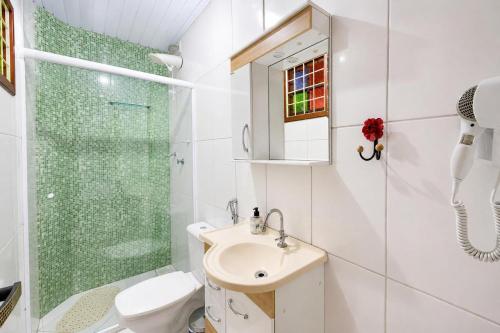 a bathroom with a toilet and a shower and a sink at Chalé Charmoso na Serra de Penedo in Penedo