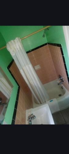 a bathroom with a mirror and a tub and a sink at Capital Motel in Columbus