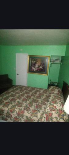 a bedroom with a bed and a painting on the wall at Capital Motel in Columbus