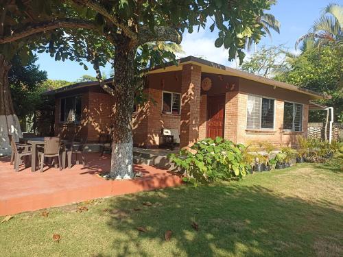a brick house with a tree in front of it at La Morada, una ventana al golfo - Hotel boutique in Monte Gordo