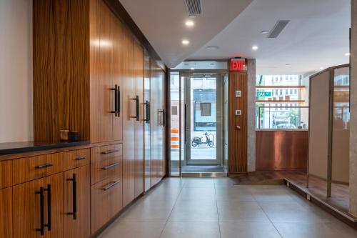 a large kitchen with wooden cabinets and a glass door at Duane Street Hotel Tribeca, Belvilla District 6 Formerly Sonder in New York