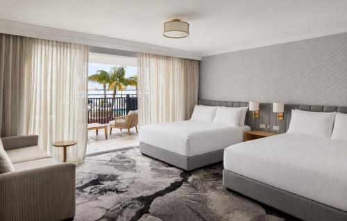 a hotel room with two beds and a couch at The Beachcomber Hotel & Resort in Toukley