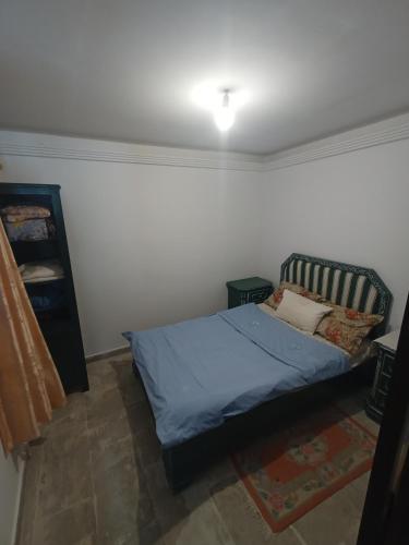 a bedroom with a bed with a blue bedspread at Maison Kram Plage in Le Kram