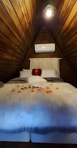 a bedroom with a bed with an apple on it at Imperatriz Cabanas (Chalé 2 com piscina e hidro) in Santo Amaro da Imperatriz