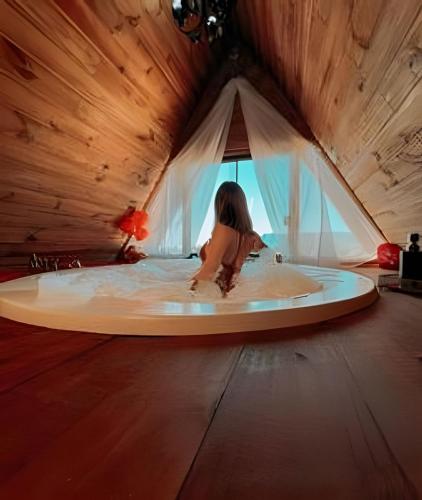 a girl sitting in a bath tub in a room at Imperatriz Cabanas (Chalé 2 com piscina e hidro) in Santo Amaro da Imperatriz