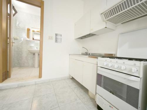 a white kitchen with a sink and a stove at Le casette Punta Pizzo in Gallipoli