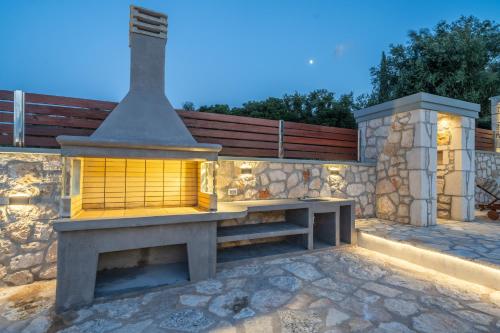 a fireplace in a stone wall with a bench at Villa Amantia in Chaliotata