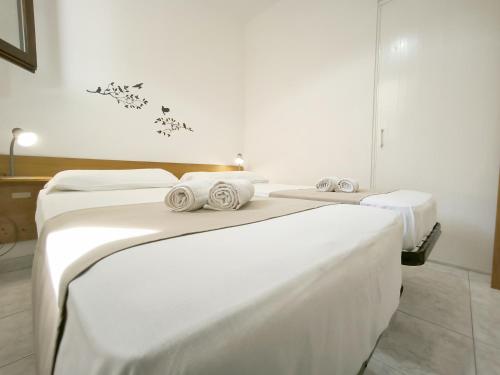 a room with three beds with white sheets at Le casette Punta Pizzo in Gallipoli