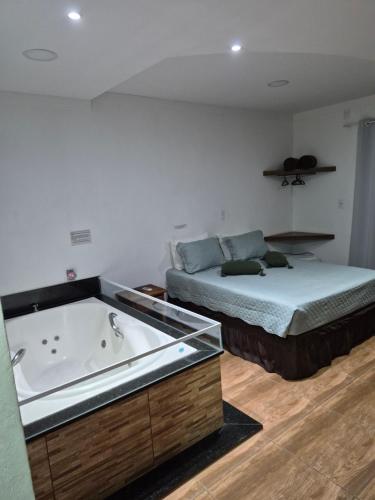 a bedroom with a bed and a bath tub at Pousada Morada do Sol in Socorro
