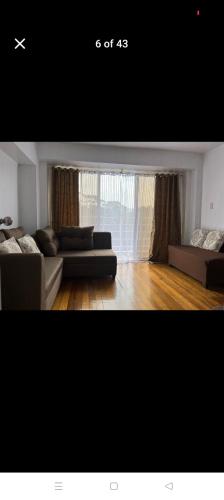 a living room with a couch and a large window at Jenny's accomodation in Baguio