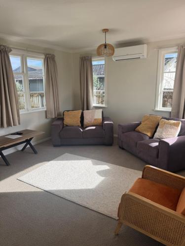 a living room with two couches and a table at Bristol Motel - HOUSE in Upper Hutt