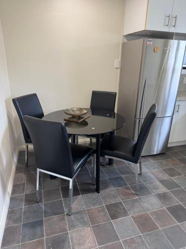 a kitchen with a table and chairs and a refrigerator at Bristol Motel - HOUSE in Upper Hutt