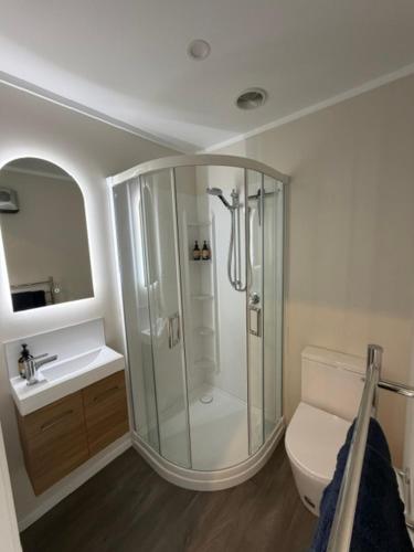 a bathroom with a shower and a toilet and a sink at Omarama Crib Spotless Scenic Base for Families in Omarama