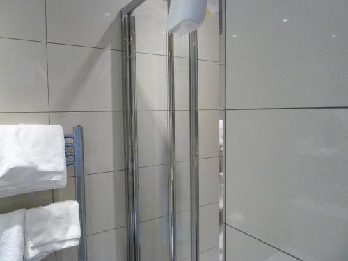a glass shower in a bathroom with towels at Edgar Townhouse in Bath