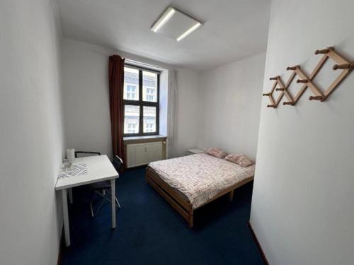 a bedroom with a bed and a desk and a window at StayPoz-Stary Rynek in Poznań