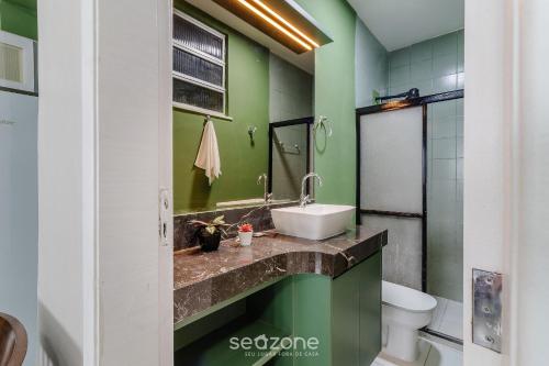 a green bathroom with a sink and a toilet at Studio the city center 300m Pelourinho HAI0203 in Salvador