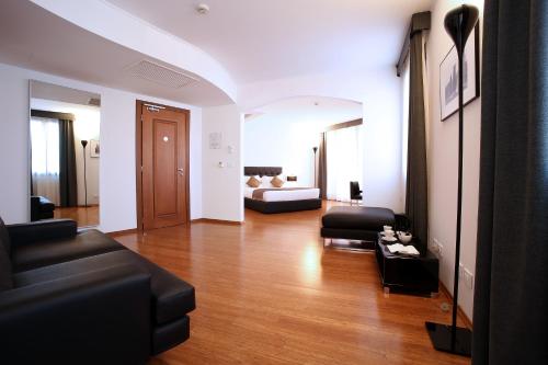 a living room with a couch and a bed at Hotel San Rocco in Muggia
