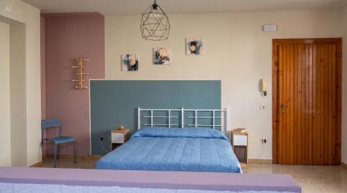 a bedroom with a blue bed and a wooden door at Affittacamere San Nicola in Montella