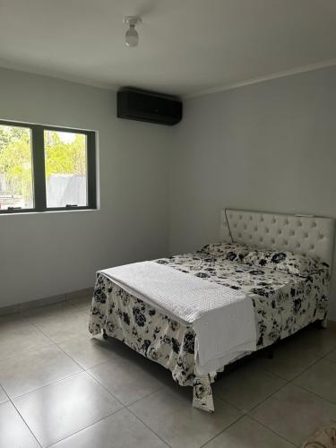 a bed in a white room with a bedspread on it at Residential Florence Nightingale in Sorriso
