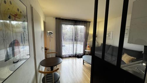 a room with a table and a bed and a window at Independent studio - Cicé Blossac Golf in Bruz