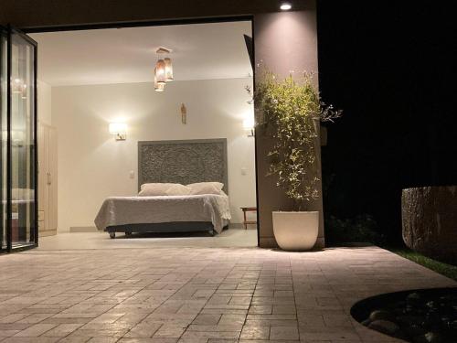 a bedroom with a bed and a potted plant at Casa de Campo Urpichay in Ricardo Palma