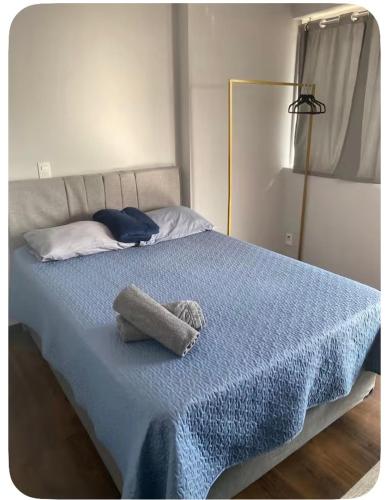a bed with a blue blanket and a stuffed animal on it at The Cittyplex Osasco - new flat in Osasco