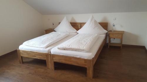 two beds with white sheets and pillows in a room at Pension Christina in Vaihingen an der Enz