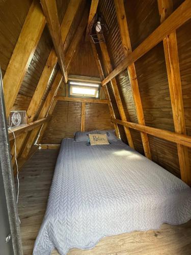 a bed in a wooden cabin with a roof at Vibra Barranquitashot pool in Barrancas