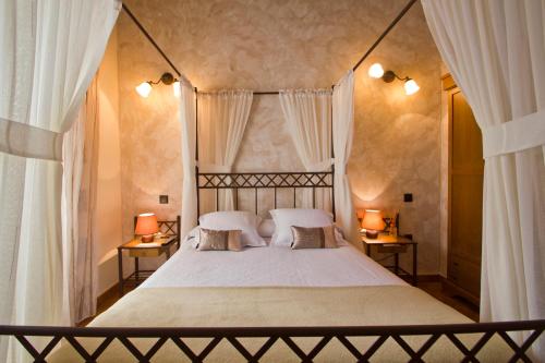 a bedroom with a large white bed with two lamps at Posada La Fabula in Santillana del Mar