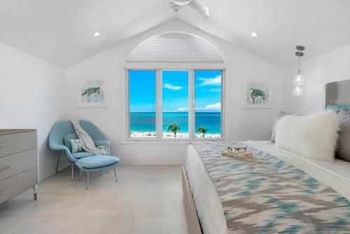 a bedroom with a bed and a view of the ocean at Grace Bay Beach Front Penthouse in Long Bay Hills
