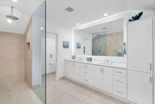 a white bathroom with a sink and a mirror at Grace Bay Beach Front Penthouse in Long Bay Hills