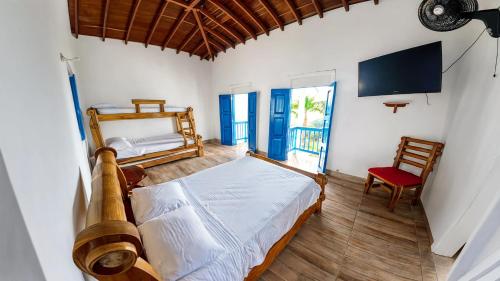 a bedroom with a bed and a tv and a chair at Finca Hotel Monte Carlos in Santa Bárbara