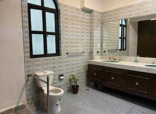 a bathroom with a toilet and a sink and a mirror at Hostel Paricutín in Uruapan del Progreso