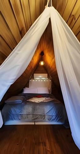 a bed in a tent in a room at Imperatriz Cabanas (Chalé 1 com hidromassagem) in Santo Amaro da Imperatriz