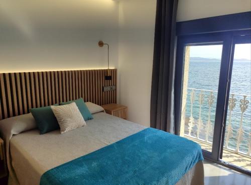 a bedroom with a bed with a view of the ocean at Principe in Sanxenxo