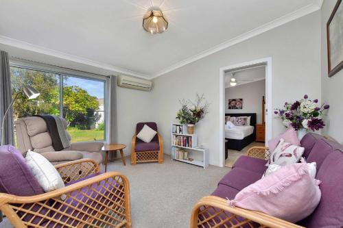 a living room with purple furniture and a bedroom at Morpeth Cottage in Morpeth