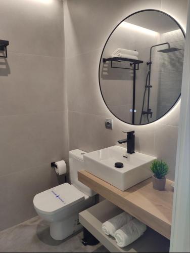a white bathroom with a sink and a mirror at Principe in Sanxenxo