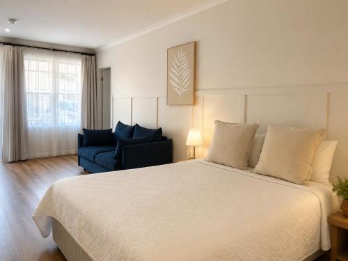 a bedroom with a large bed and a blue couch at Cooks Endeavour Motor Inn - Near beach & Gold Coast Airport in Tweed Heads