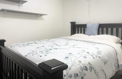 a bedroom with a bed with a white comforter at Cozy Ocean View Retreat in Victoria